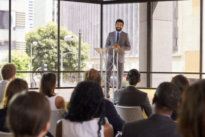 Hispanic man presenting business seminar smiling to audience