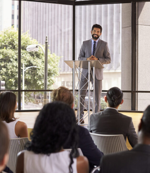 Hispanic man presenting business seminar smiling to audience